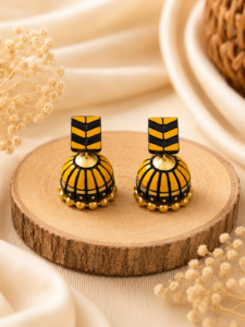 Amber Stack handmade terracotta jhumki earrings displaying a unique layered geometric design hand-painted in warm amber and gold.
