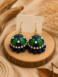 Peacock Polka handmade terracotta hanging jhumka earrings showcasing hand-painted peacock blue and teal domes adorned with fine polka dot artistry.