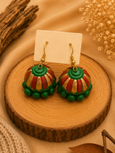 Sunset Carnival handmade terracotta hanging jhumka earrings featuring hand-painted traditional tiered clay designs in festive orange, red, and gold.