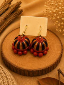Sunset Spin handmade terracotta hanging jhumka earrings featuring a hand-painted spiral design in vibrant orange, red, and gold tones.